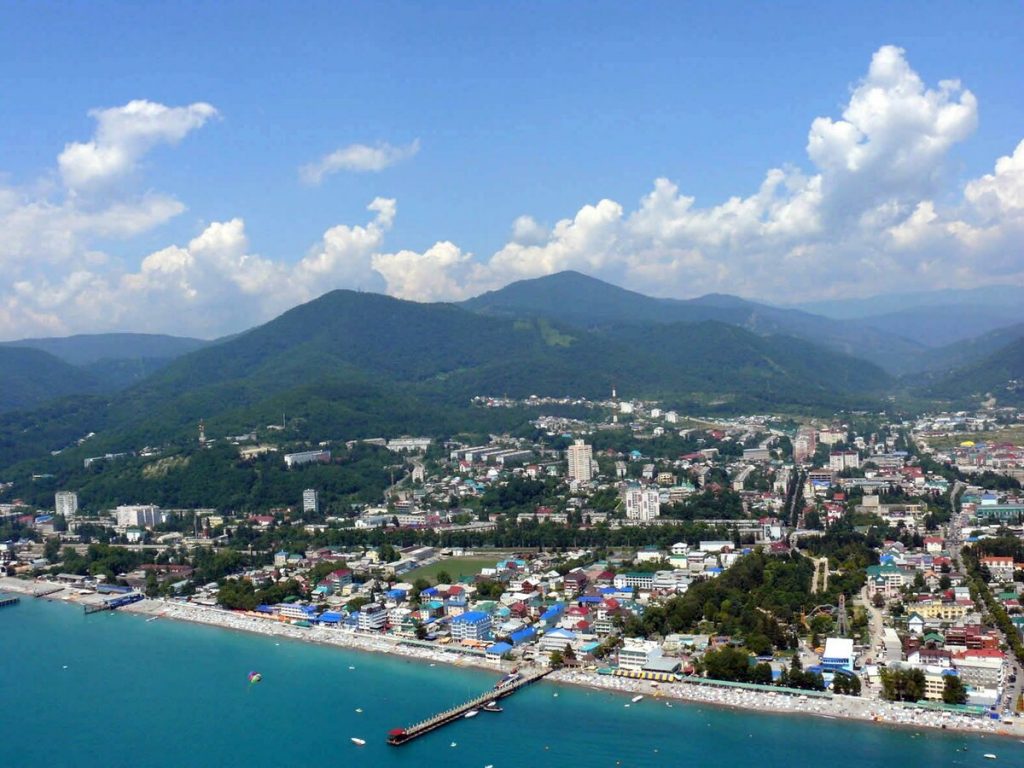 Панорама Лазаревского: прибрежный город, набережная с пляжем, пирс и зелёные холмы